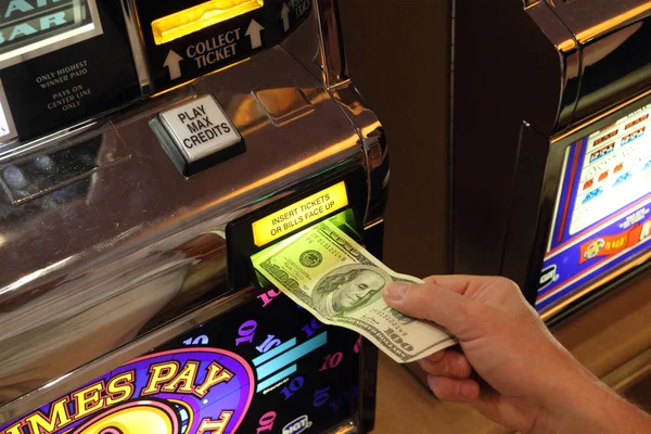 Mano poniendo dinero en la máquina tragaperras en Las Vegas —  Fotos de Stock