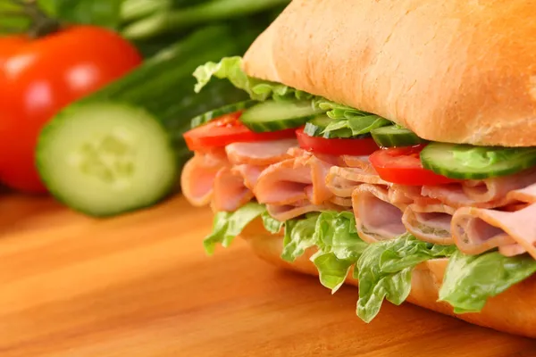 Sandwich au jambon frais sur planche de bois — Photo