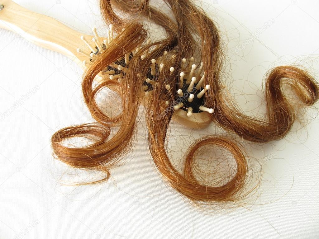 Chestnut-brown hair strand and hairbrush