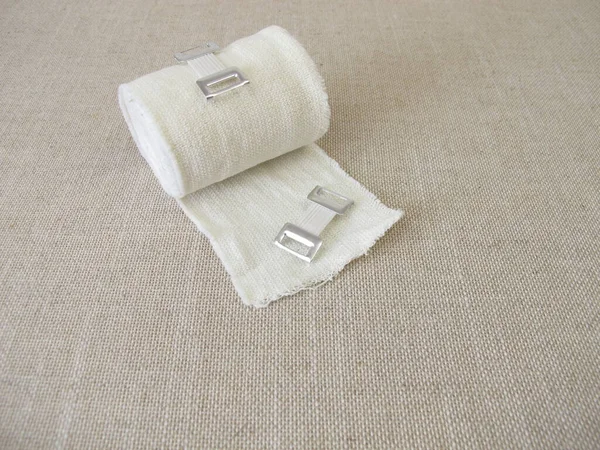 Dressing material, elastic bandage with bandage clamp