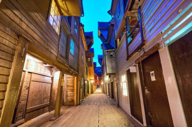 Bryggen 'daki ahşap evler arasındaki dar sokak Alacakaranlık, Bergen, Norveç
