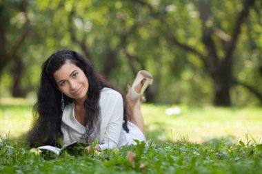 Kız bir çim üzerinde okur