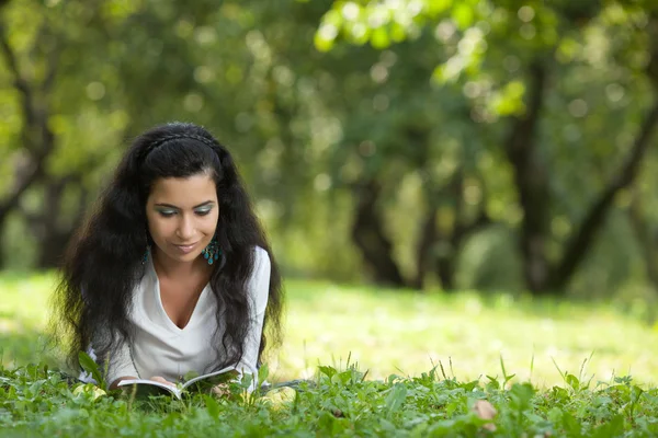 Το κορίτσι σε μια χλόη διαβάζει το βιβλίο — Φωτογραφία Αρχείου