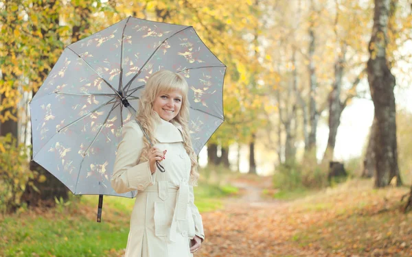 A menina com um guarda-chuva no parque de outono — Fotografia de Stock