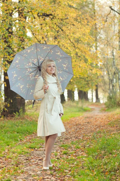 A menina com um guarda-chuva no parque de outono — Fotografia de Stock