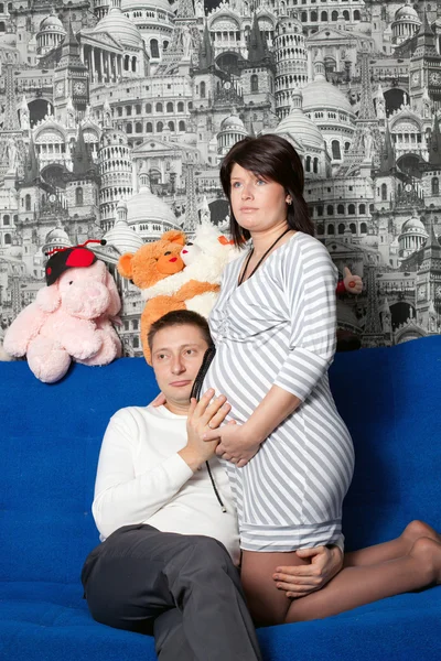 Ο άνθρωπος και η έγκυος γυναίκα σε ένα καναπέ — Φωτογραφία Αρχείου