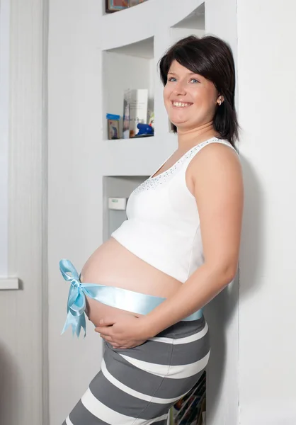 La mujer embarazada cuesta a la pared — Foto de Stock