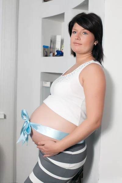 The pregnant woman costs at a wall — Stock Photo, Image