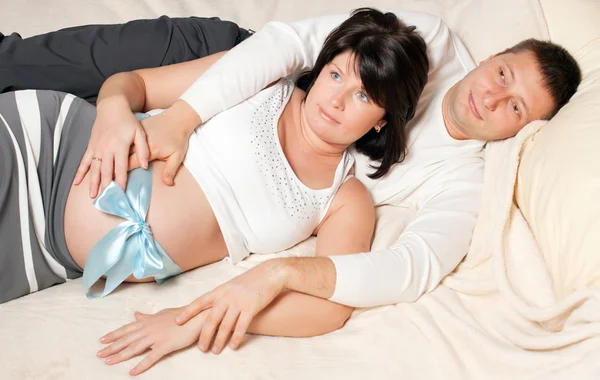 Ο άνθρωπος και η έγκυος γυναίκα σε ένα κρεβάτι — Φωτογραφία Αρχείου