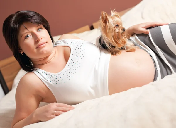 La femme enceinte est allongée sur un lit — Photo