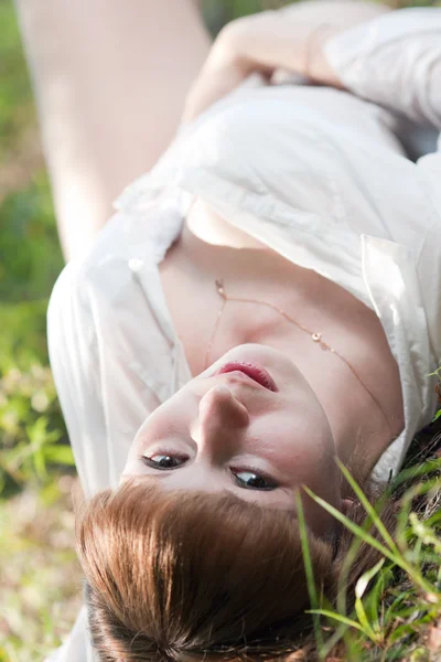 Kvinnan på ett gräs i en vit skjorta — Stockfoto