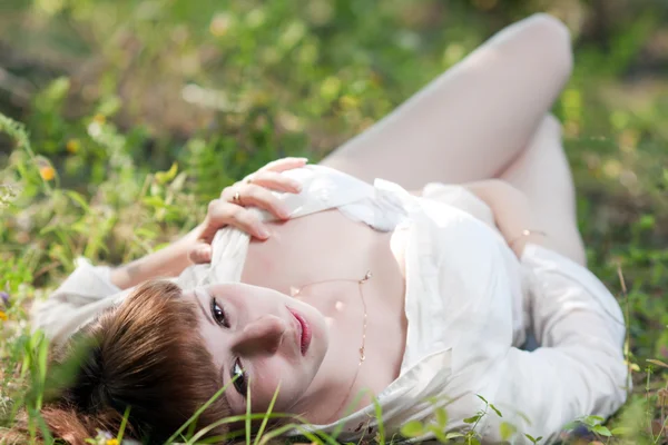 De vrouw op een gras in een wit overhemd — Stockfoto
