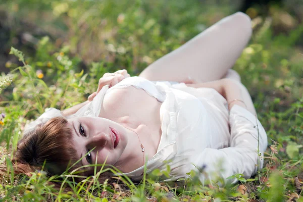 Kobieta na trawie w białej koszuli — Zdjęcie stockowe