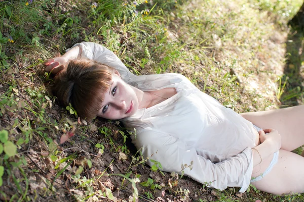 The woman on a grass in a white shirt — Stock Photo, Image