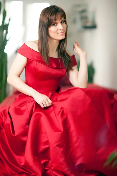 Woman in a ball gown on the sofa — Stock Photo, Image