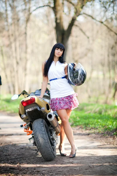 Girl standing beside a motorcycle — Stock Photo, Image