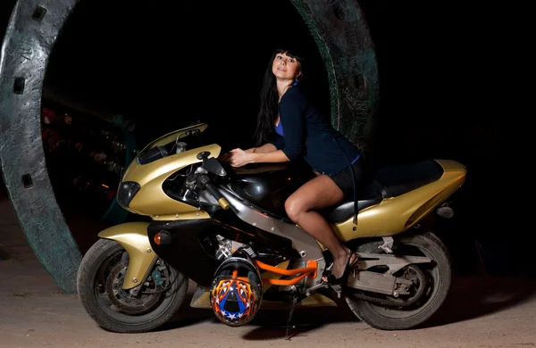 Menina sentada em uma motocicleta à noite — Fotografia de Stock