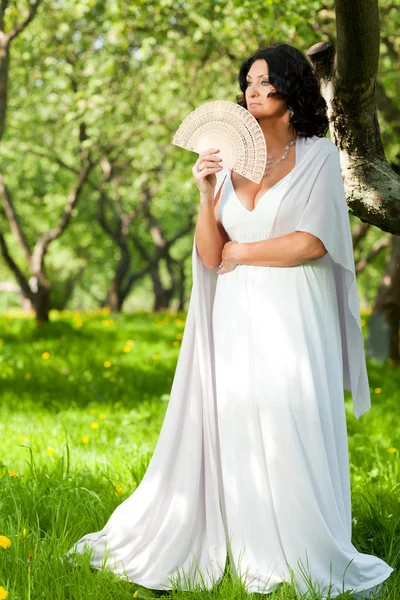 Une femme dans le parc tient un ventilateur — Photo