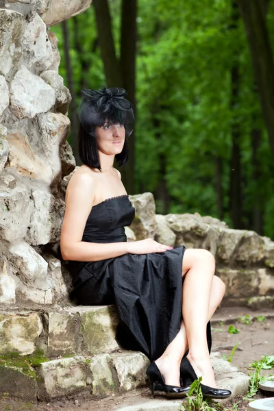 Woman sitting against the wall — Stock Photo, Image