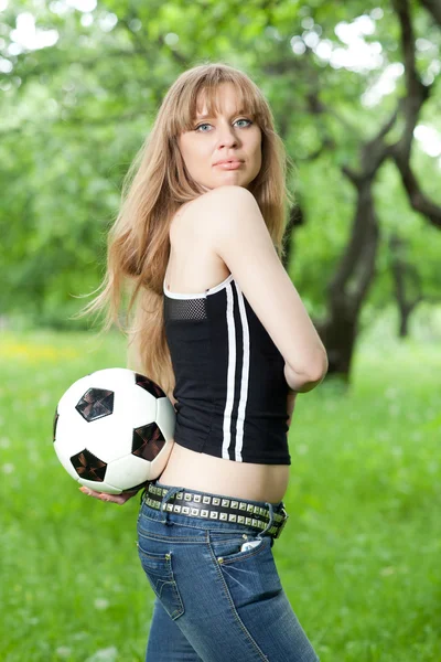 Uma mulher segurando uma bola de futebol — Fotografia de Stock