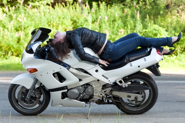 Kvinnan ligger på en motorcykel — Stockfoto