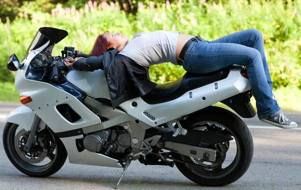 Kvinnan ligger på en motorcykel — Stockfoto