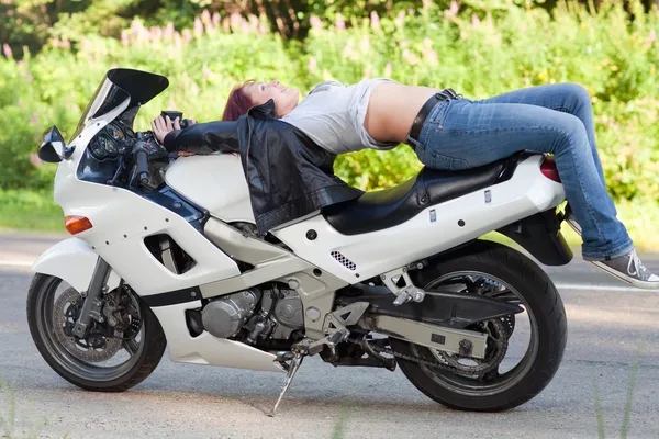 Kvinnan ligger på en motorcykel — Stockfoto