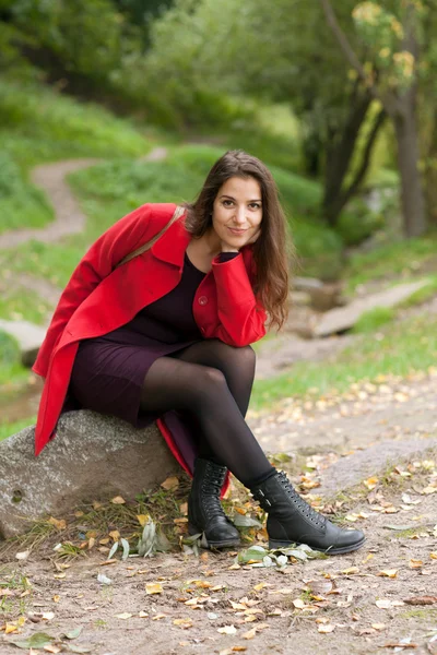 Woman sitting on a stone — Stock Photo, Image