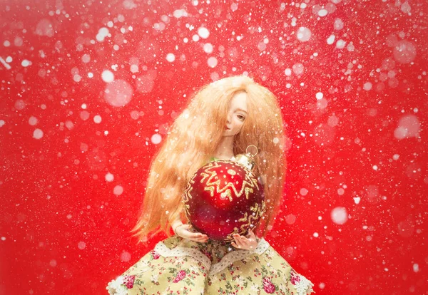 Schöne Puppe Mit Einer Weihnachtskugel Den Händen Und Schnee Auf — Stockfoto