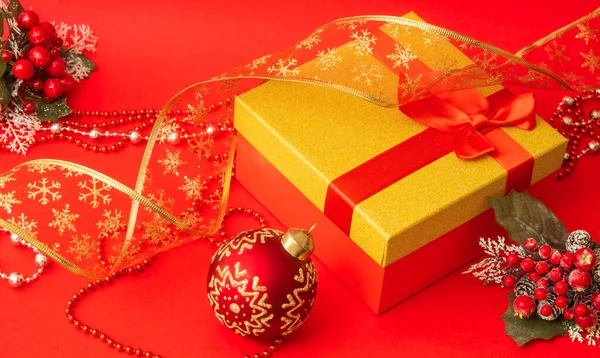 赤い背景にギフトとクリスマスボールの入った箱 — ストック写真