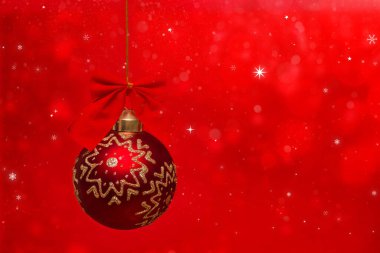 Güzel noel kırmızı topu kar taneleriyle kırmızı bir zeminde asılı.