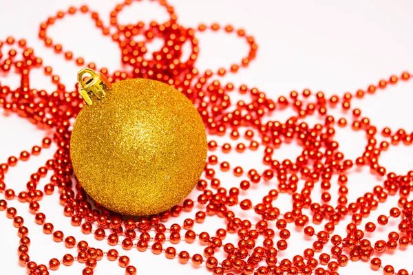 漂亮的金圣诞球和白色上的红色珠子花环 — 图库照片