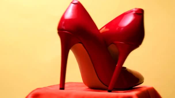 Güzel Parlak Kırmızı Topuklu Ayakkabılar Sarı Arka Planda Dönüyor — Stok video