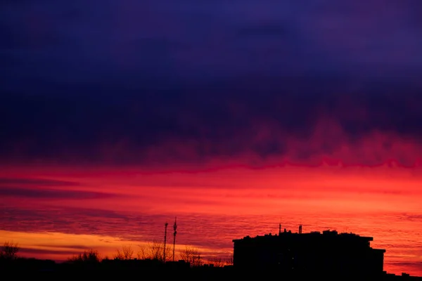 美丽的红色夕阳在房屋上方的天空中闪耀 深红色的夜空 — 图库照片