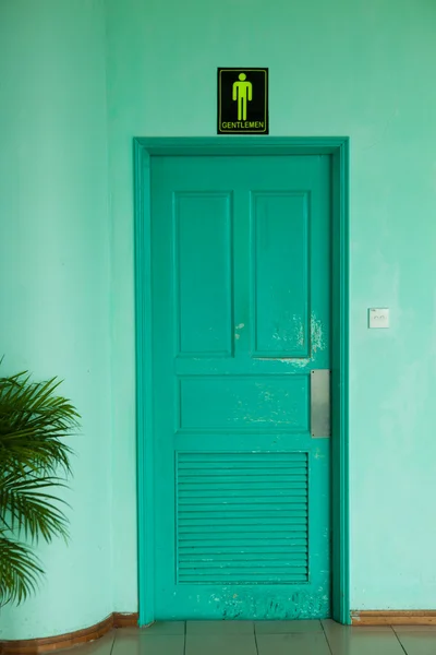 Porta de madeira no fundo da parede verde — Fotografia de Stock