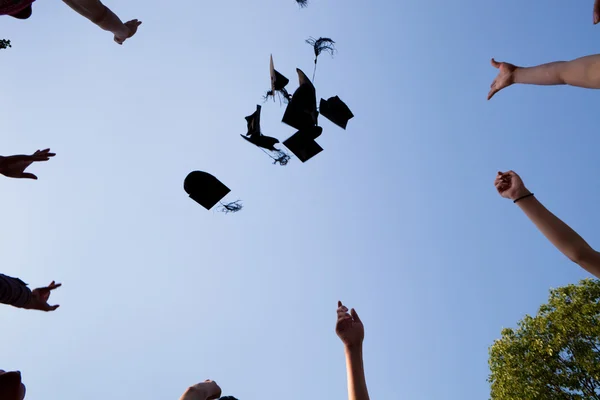 Middelbare school afstuderen hoeden hoge — Stockfoto
