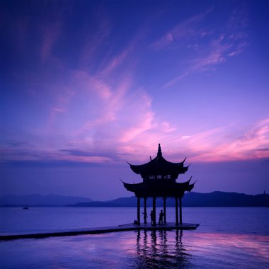 antiguo pabellón en el lago del oeste con puesta de sol en hangzhou, china.