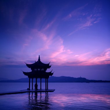 antiguo pabellón en el lago del oeste con puesta de sol en hangzhou, china.