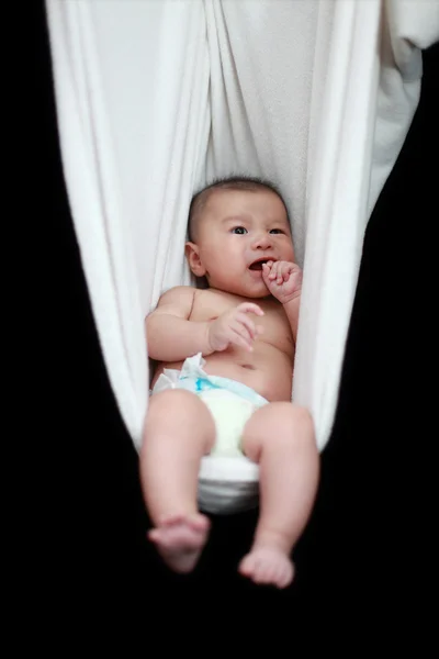 Naakte baby slapen in witte hangmat sling, geïsoleerd op een zwarte achtergrond. — Stockfoto
