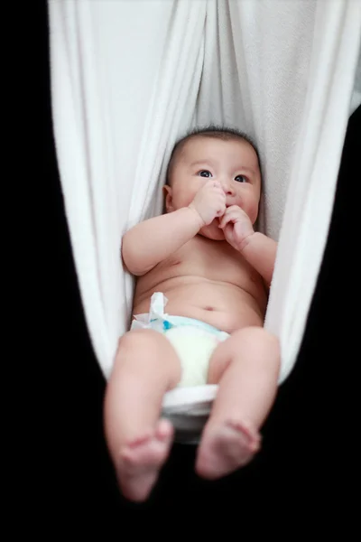 Naked Baby sleeping in White Hammock Sling, isolated on a black background. — Stock Photo, Image