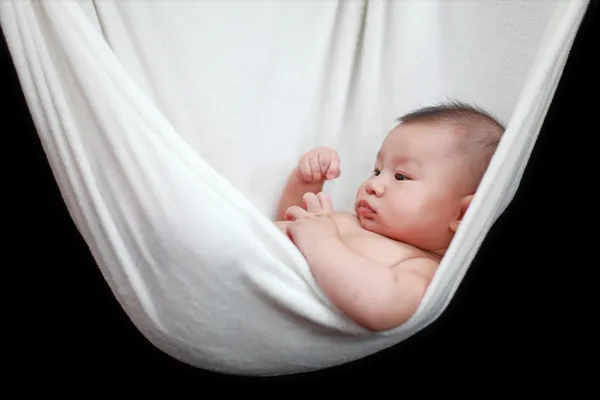 Naked Baby sleeping in White Hammock Sling, isolated on a black background. — Stock Photo, Image