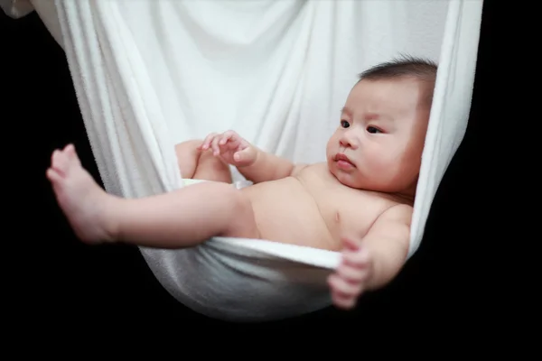 Naked Baby sleeping in White Hammock Sling, isolated on a black background. — Stock Photo, Image