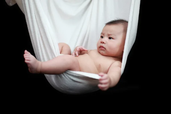 Naked Baby sleeping in White Hammock Sling, isolated on a black background. — Stock Photo, Image