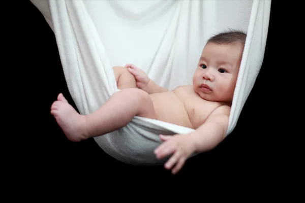 Naked Baby sleeping in White Hammock Sling, isolated on a black background. — Stock Photo, Image