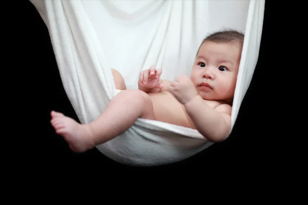 Naked Baby sleeping in White Hammock Sling, isolated on a black background. — Stock Photo, Image