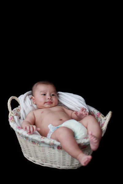 Niedliches Baby im Korb mit schwarzem Hintergrund — Stockfoto