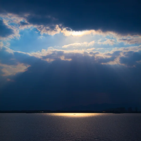 À travers les nuages sur la rivière, la lumière coule — Photo