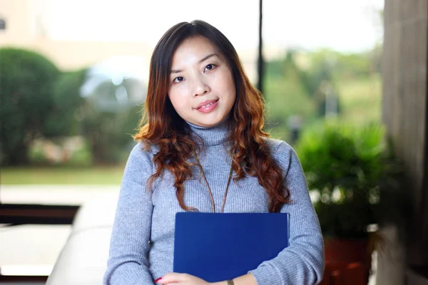 Smiling asian business woman holding with folder in office — Stok Foto