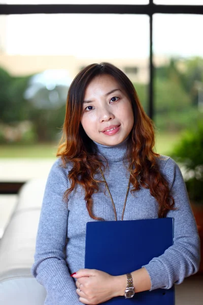 Sorrindo asiático mulher de negócios segurando com pasta no escritório — Fotografia de Stock