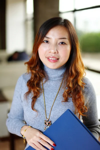 Sonriendo asiático negocio mujer holding con carpeta en oficina —  Fotos de Stock